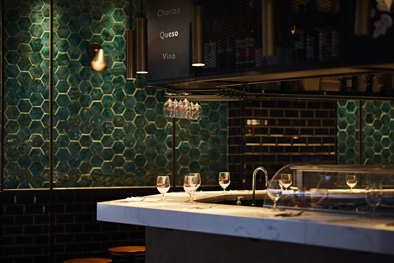 Brindisa marble bar with an emerald and gold wall in the background