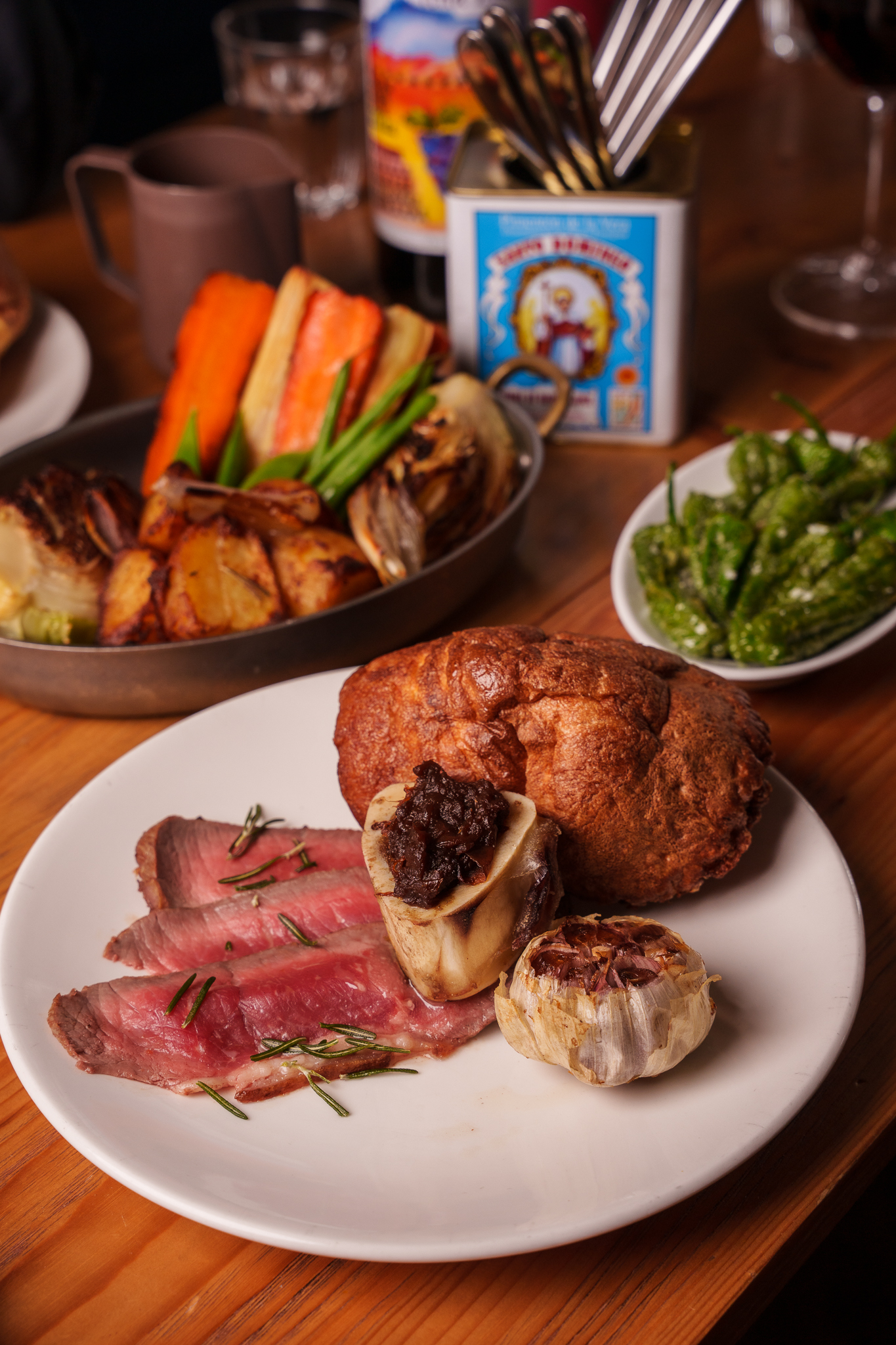 A tablescape featuring the Brindisa Tapas roast of Galician beef sirloin, seasonal vegetables and ibérico fat roast potatoes