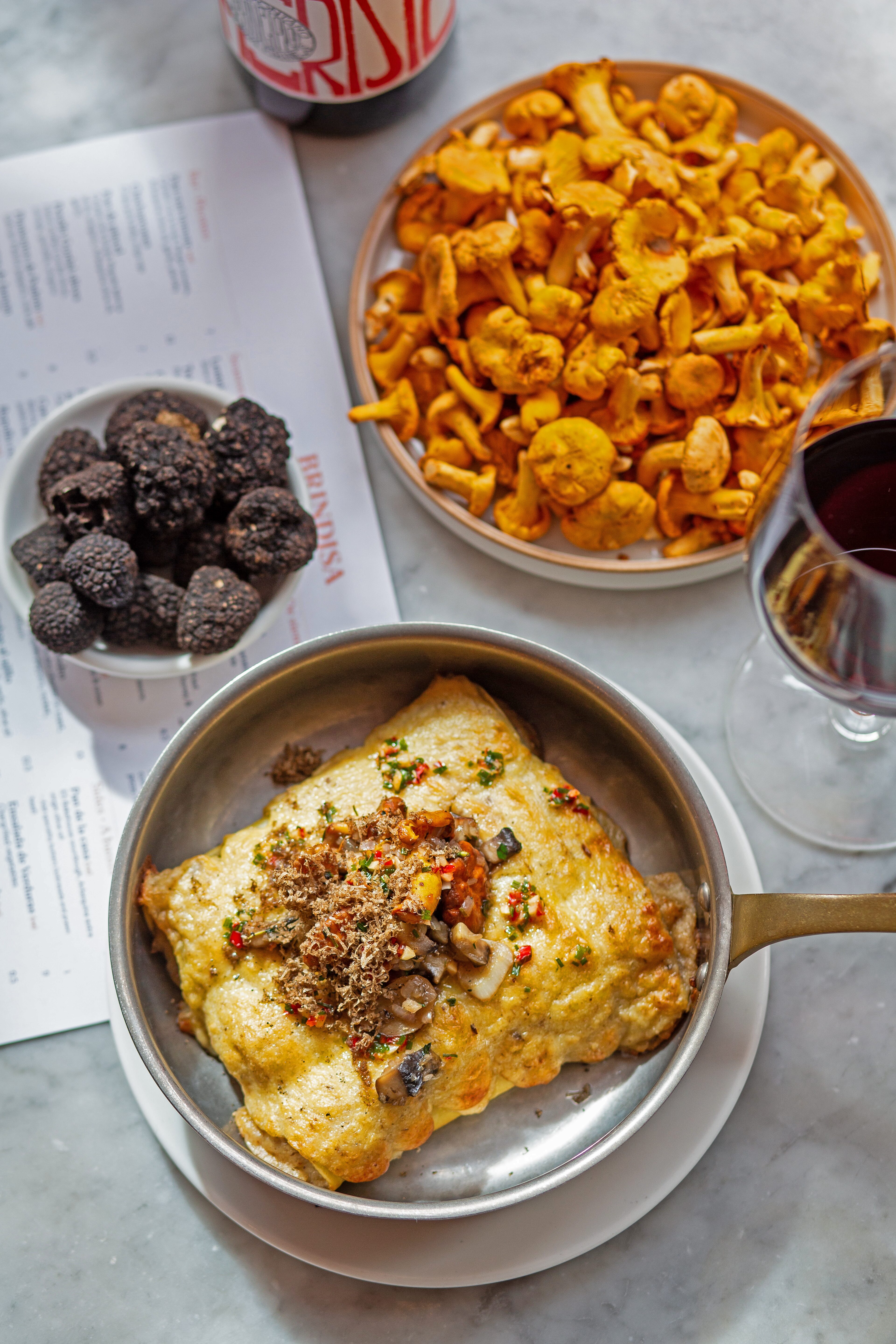 Canelones de setas, with mushrooms, truffle and a glass of red wine on the table